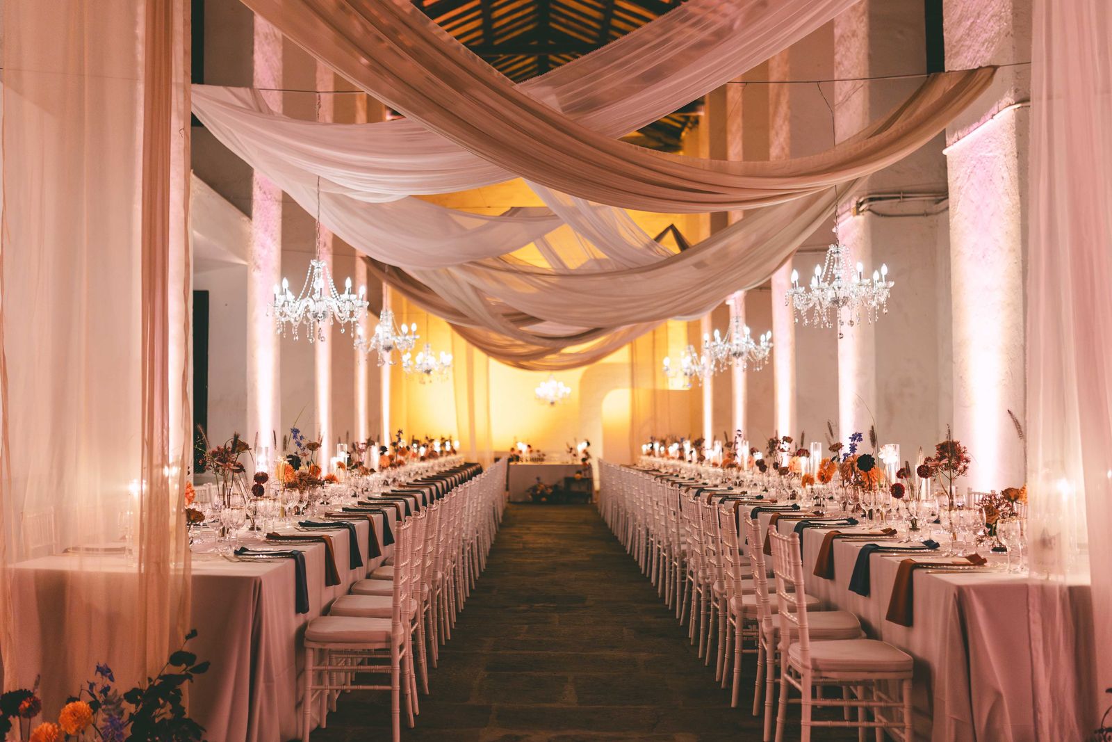 Ricevimento di matrimonio in un salone con drappi e lampadari, allestito da &Eacute;moilab